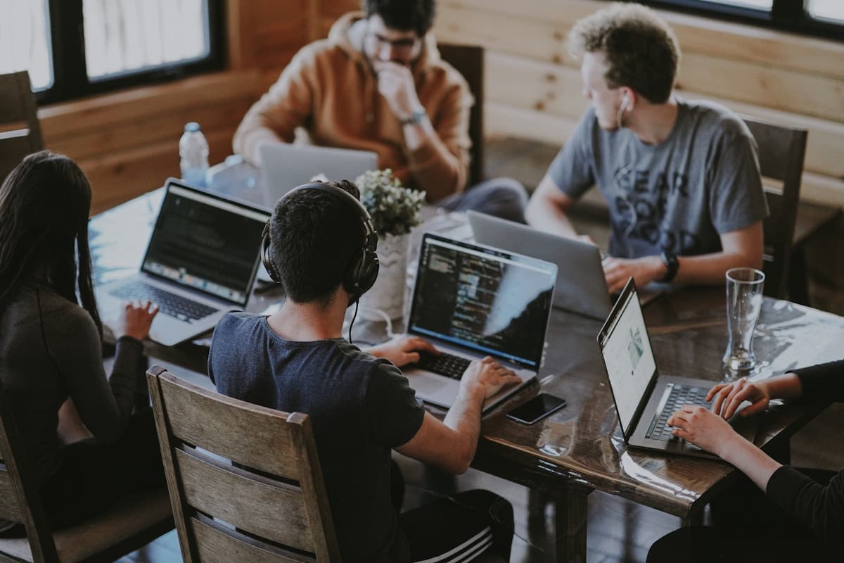 Diverse team collaborating on marketing strategy around a laptop